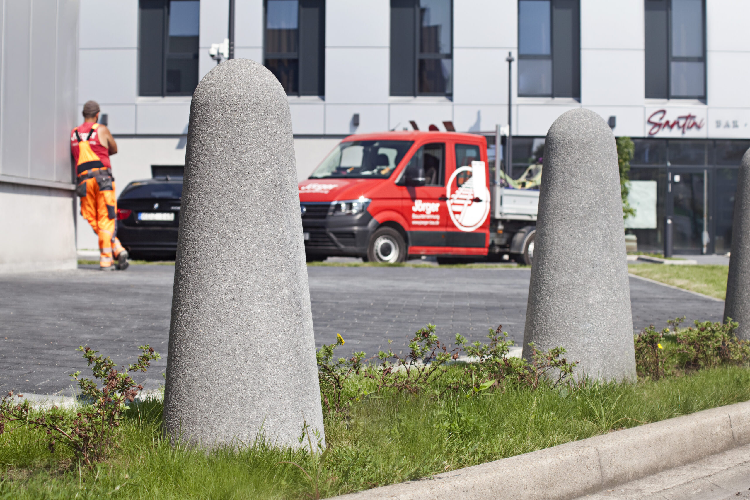  HOF & AUSSENANLAGEN: Betonpoller und Bauarbeiter von Jörger im Hintergrund