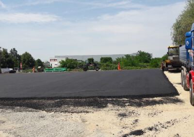 Frisch asphaltierte Fläche mit Fahrzeugen