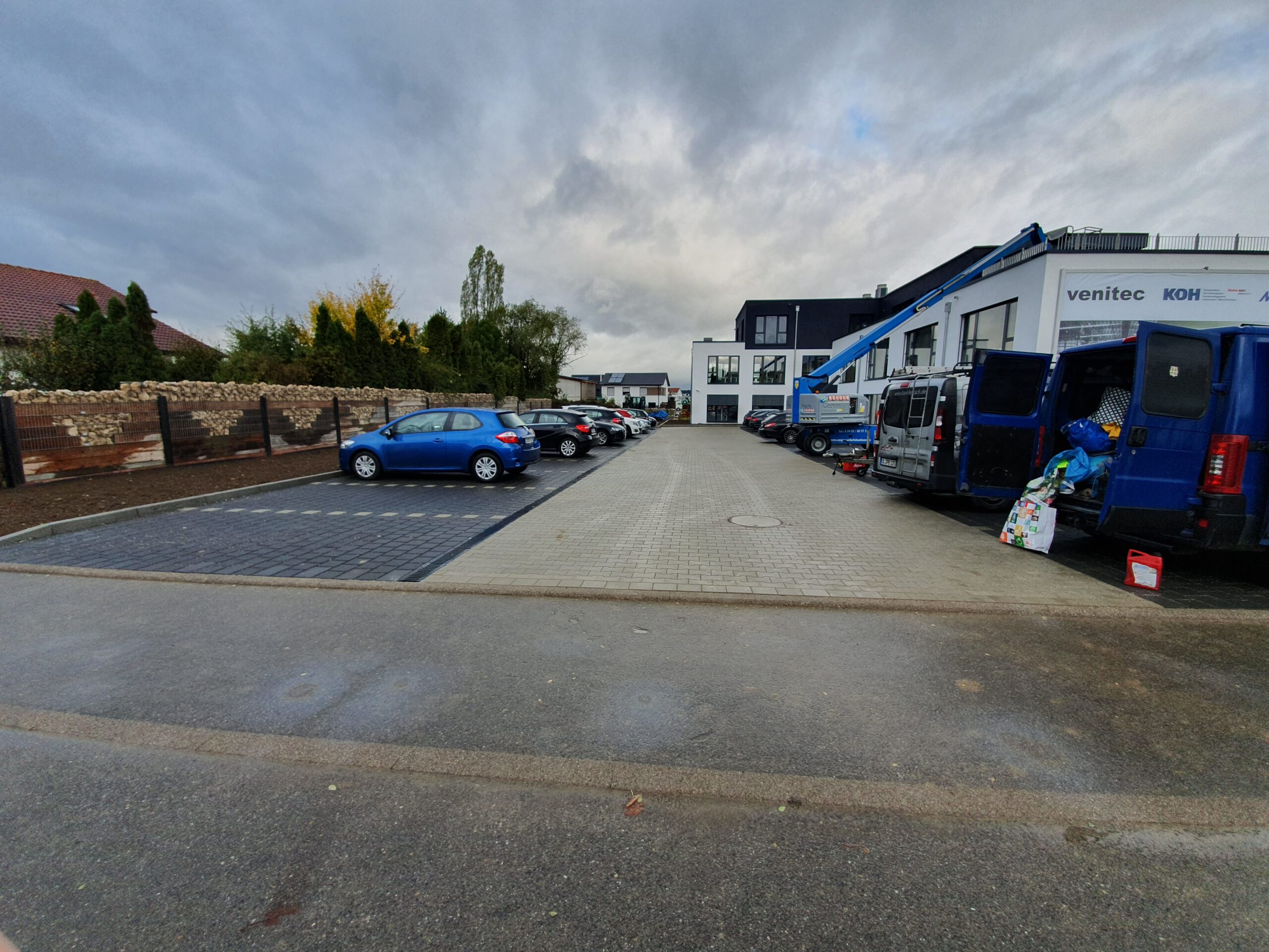  INDUSTRIEHOF & PARKPLATZBAU: Parkplatz mit mehreren Autos und Gebäuden