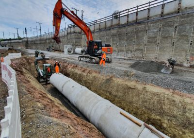 Bagger arbeitet an Rohrverlegung.