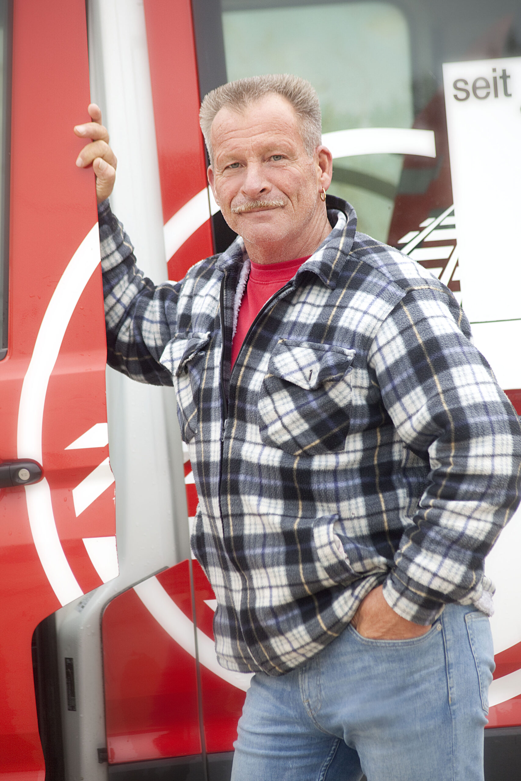Dietmar Pernesch: Oberpolier. Mann in kariertem Hemd vor Fahrzeug