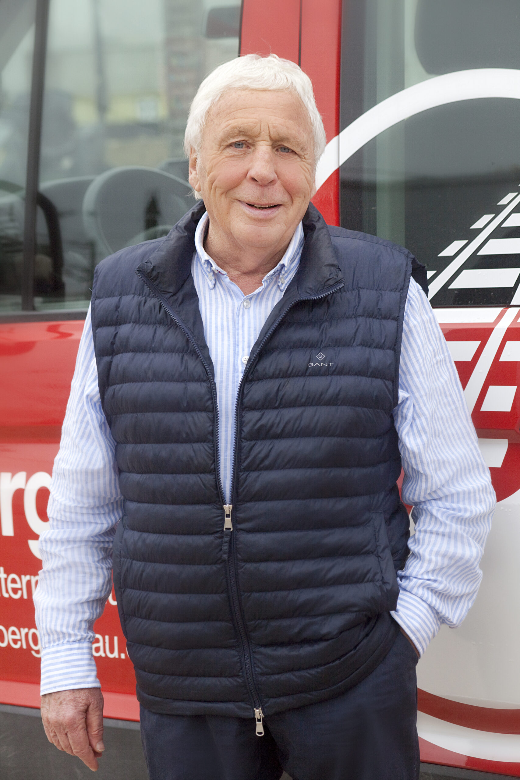 Konrad Jörger: Seniorchef, Berater. Mann in blauer Weste vor Bus