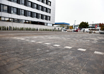 Leerer Parkplatz vor modernem Gebäude.