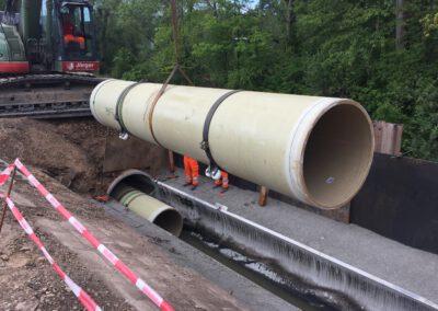 Bagger arbeitet an Rohrverlegung.
