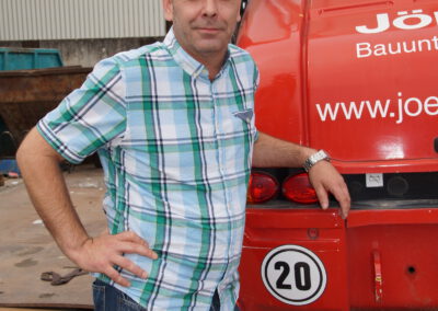 Mirko Schumann: Kalkulation. Mann neben rotem Baugerät.