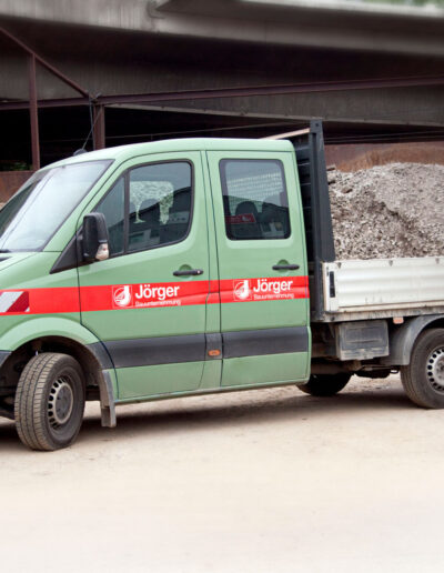 Grüner Transporter neben Schüttgut