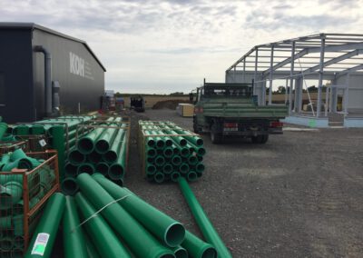 Grüne Rohre auf Baustelle gestapelt